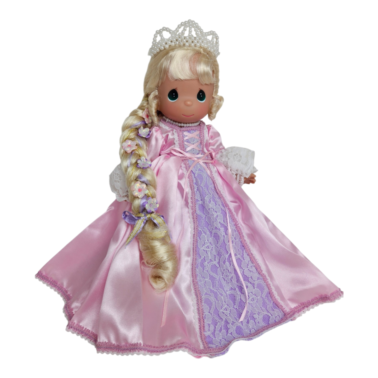 The Doll Maker 12-inch Rapunzel doll wearing a pink satin dress with lace details, a pearl tiara, and long braids.