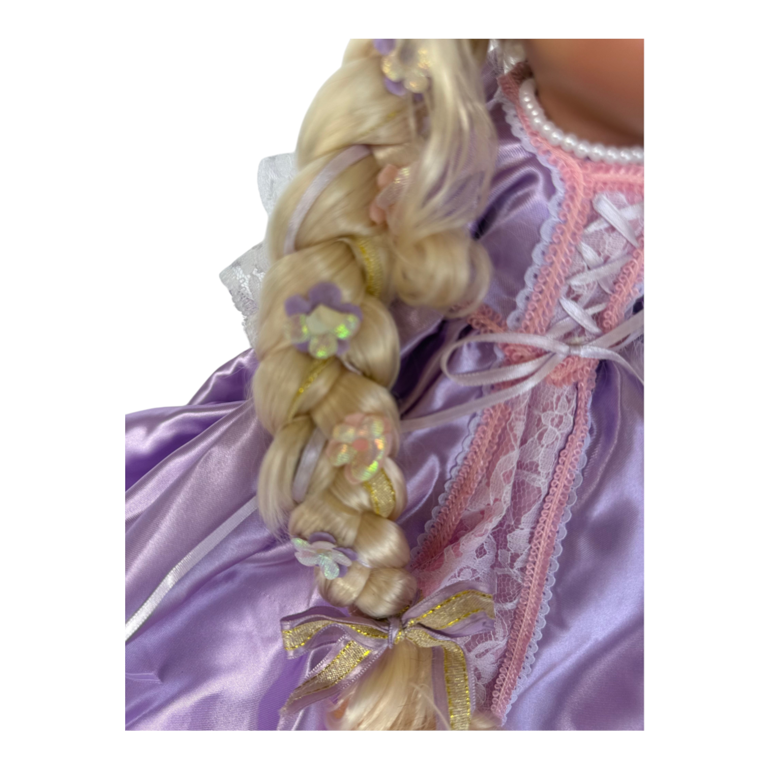 The Doll Maker 12-inch Rapunzel doll featuring a long blonde braided hair decorated with small purple flower accents.