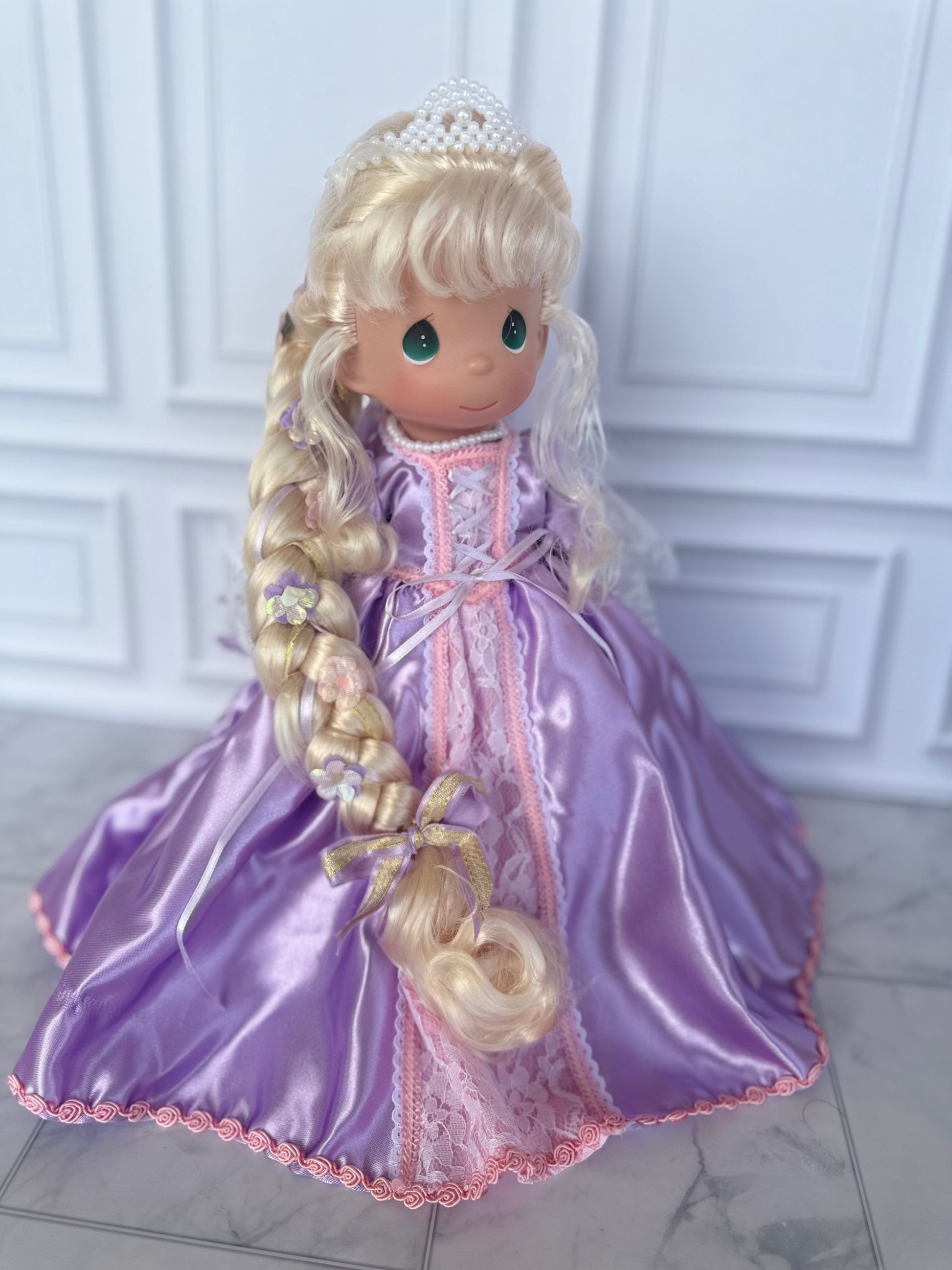 The Doll Maker 12-inch Rapunzel doll with long blonde braided hair, wearing a purple satin gown with lace trim.