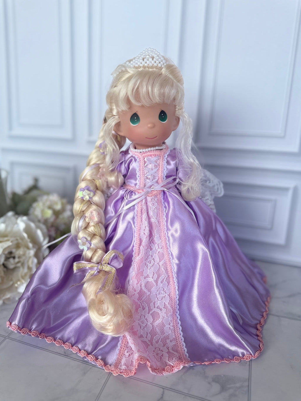 The Doll Maker 12-inch Rapunzel doll with long blonde braided hair, wearing a purple satin gown with lace trim.