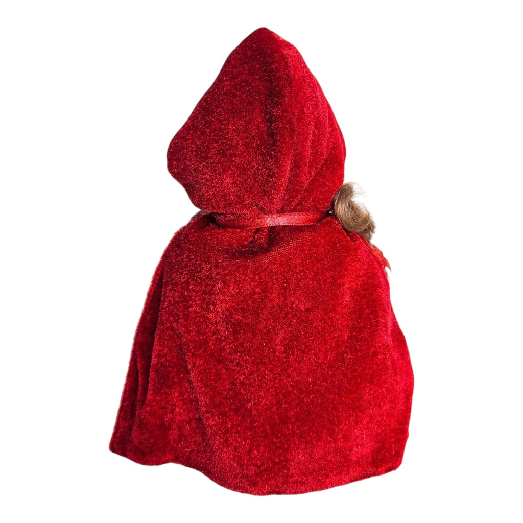 The Doll Maker Lil Red Riding Hood 7-inch vinyl doll wearing a vibrant red velvet hooded cape, back view.