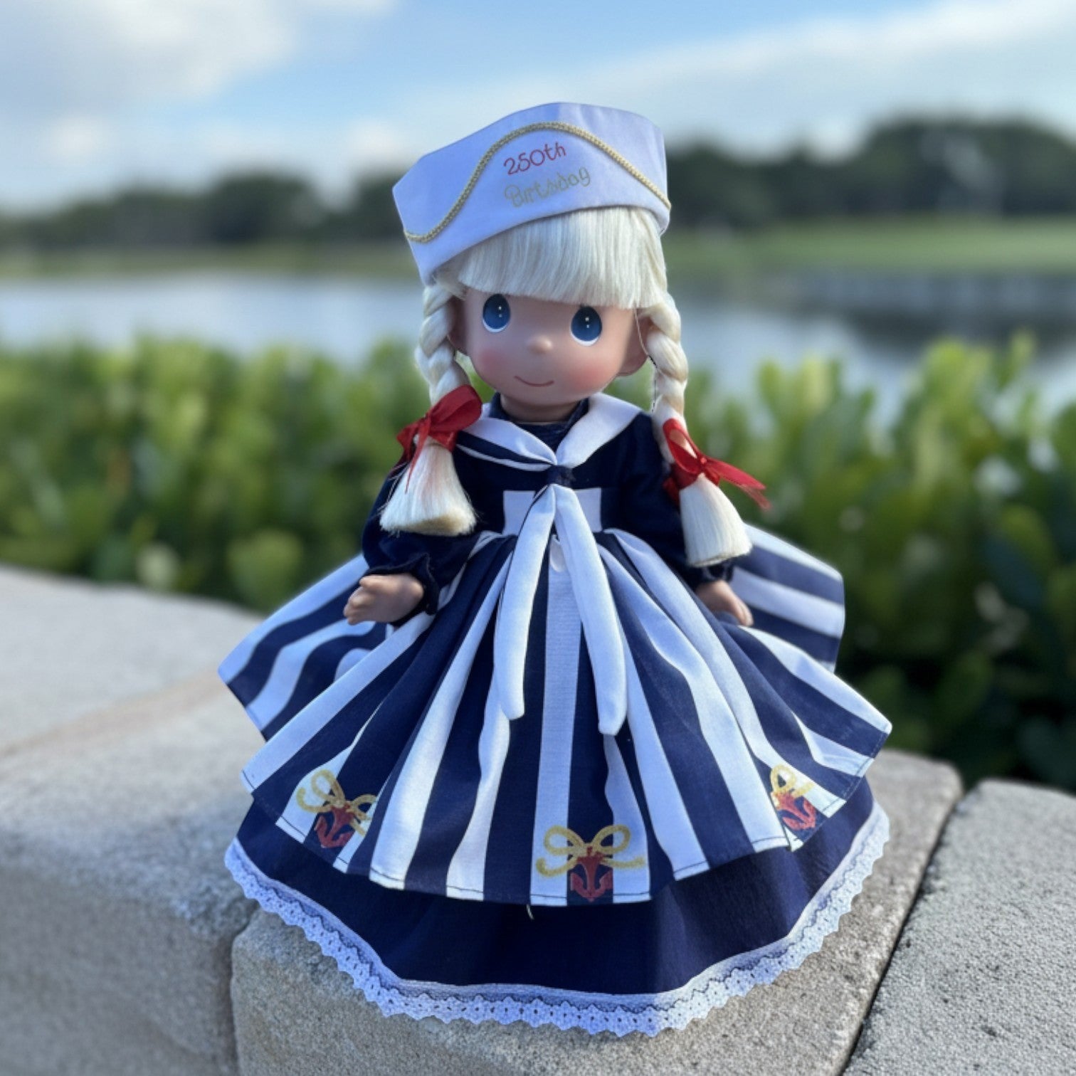The Doll Maker 12-inch commemorative doll in a navy and white striped sailor dress with 250th Birthday hat