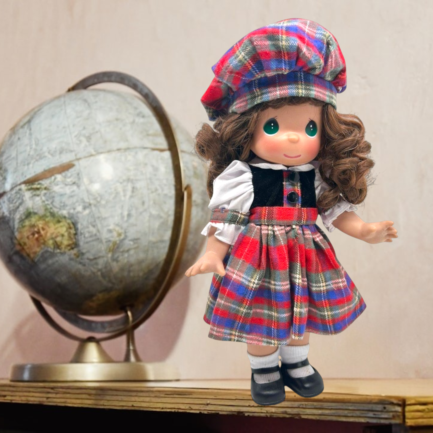The Doll Maker 12-inch Scottish doll wearing a traditional red tartan dress and matching tam o shanter hat