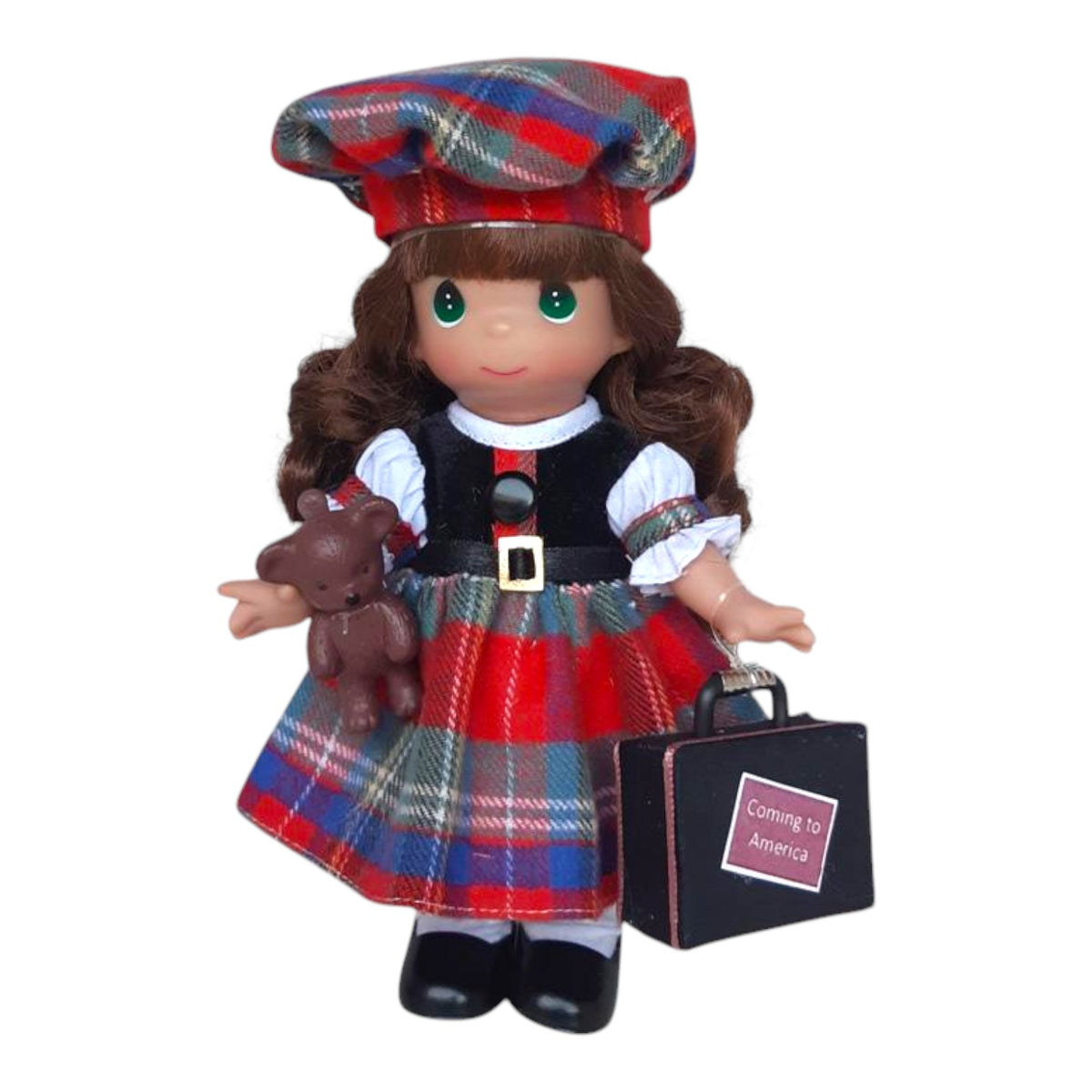 The Doll Maker 7-inch vinyl doll in a Scottish tartan outfit with a matching hat, holding a teddy bear and suitcase.