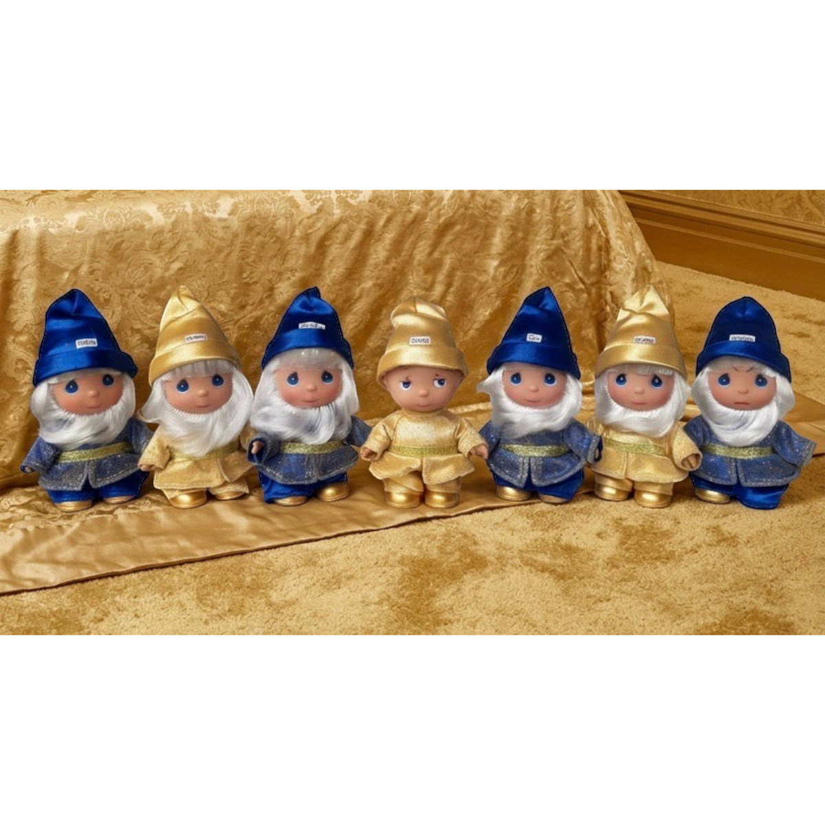 The Doll Maker 50th anniversary Seven Dwarfs doll set in blue and gold outfits with hand-finished details.