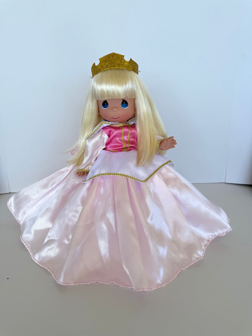 The Doll Maker 12-inch Sleeping Beauty doll with blonde hair, gold crown, and a satin pink and white princess dress.