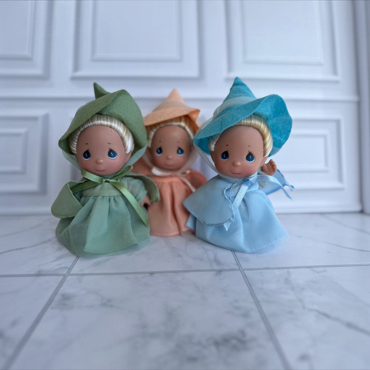 The Doll Maker set of three 5-inch Sleeping Beauty fairy dolls in green, peach, and blue dresses signed by Linda Rick.