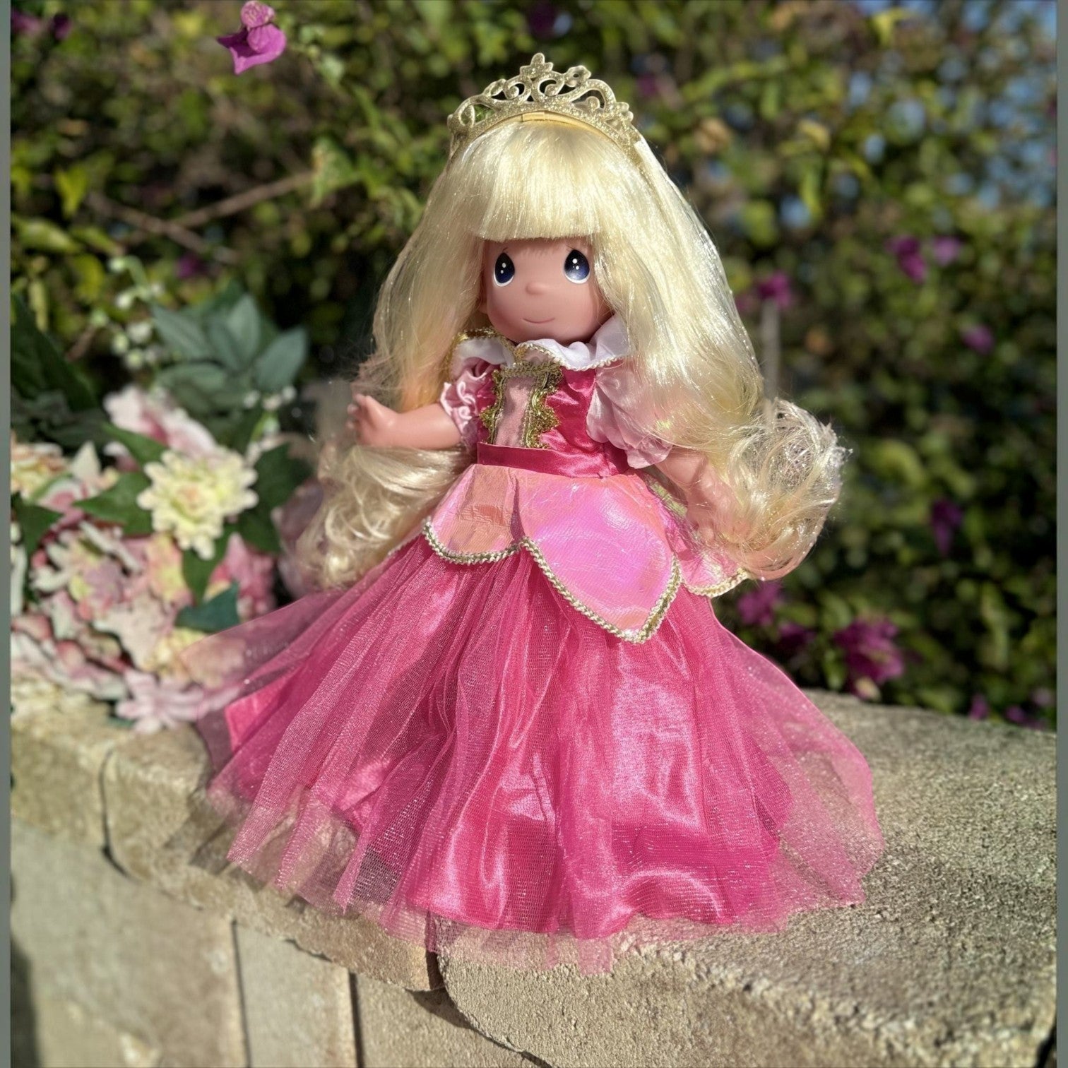 The Doll Maker Sleeping Beauty Elegance collectible doll in a dark pink tulle gown with a gold tiara and blonde hair.