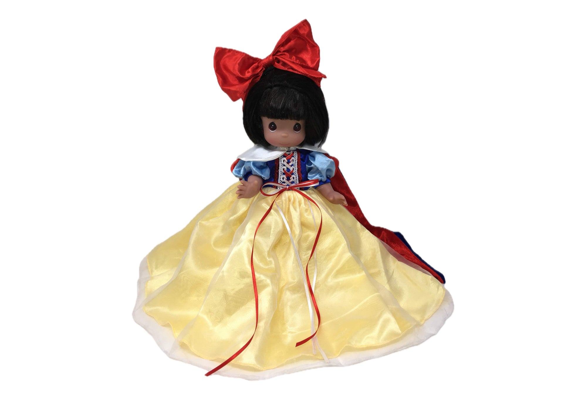 The Doll Maker 12-inch Snow White collectible doll with a yellow satin skirt, blue bodice, and large red hair bow.