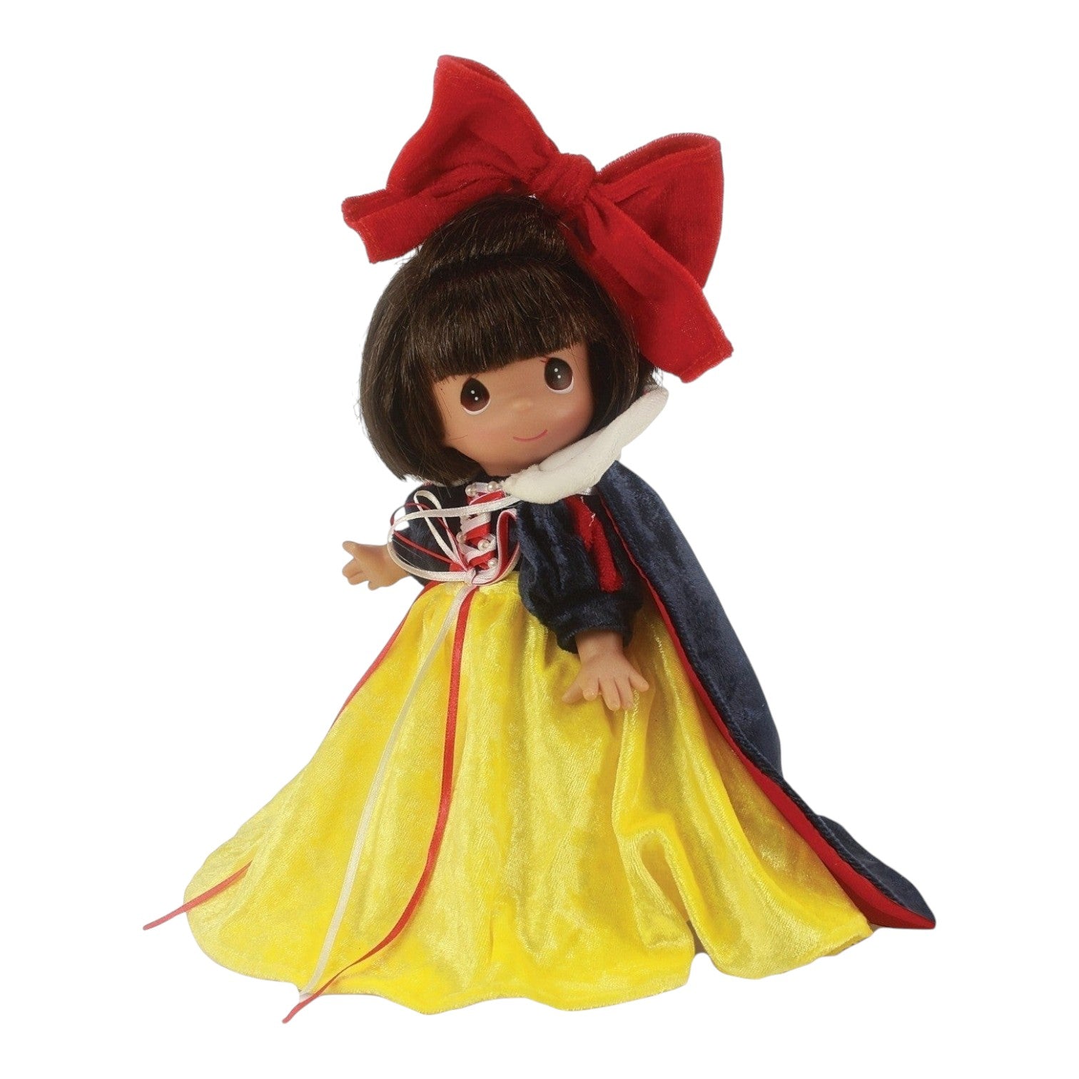 The Doll Maker 9-inch Enchanted Snow White vinyl doll with a large red bow, yellow skirt, and blue velvet cape.