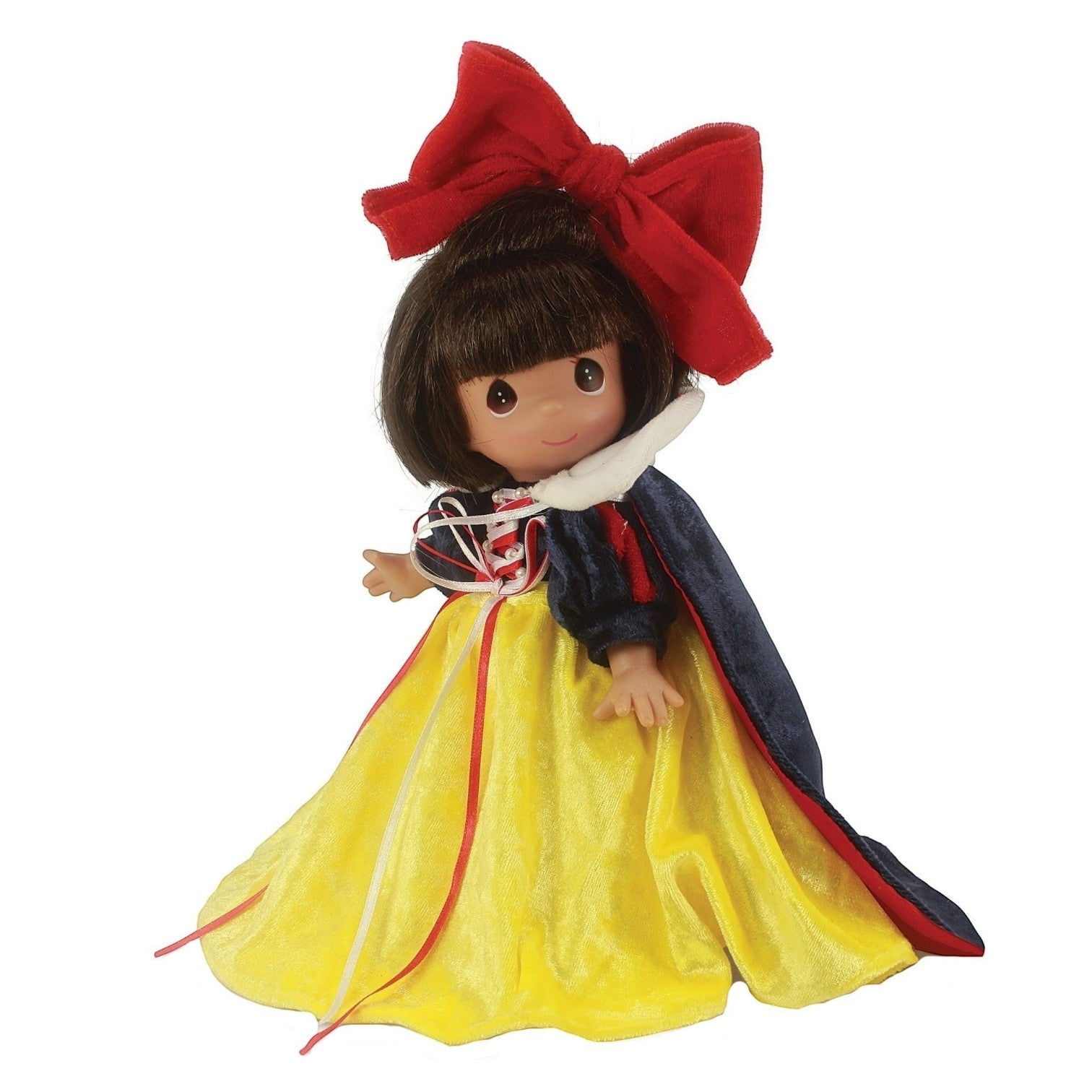 The Doll Maker Enchanted Snow White 9-inch vinyl doll wearing a yellow dress, blue cape, and large red hair bow.