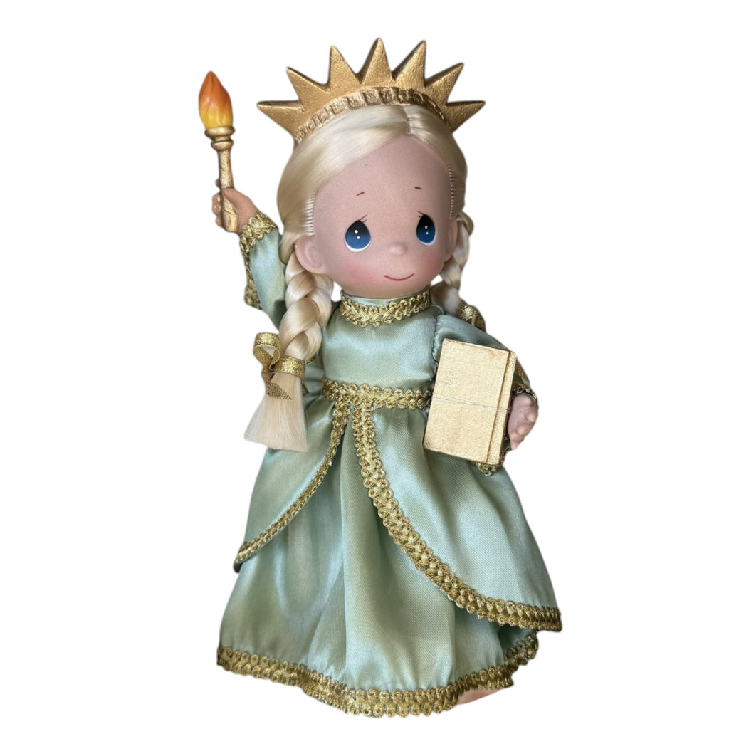 The Doll Maker 9-inch Statue of Liberty doll in a green dress with a gold crown, torch, and book for USA anniversary.