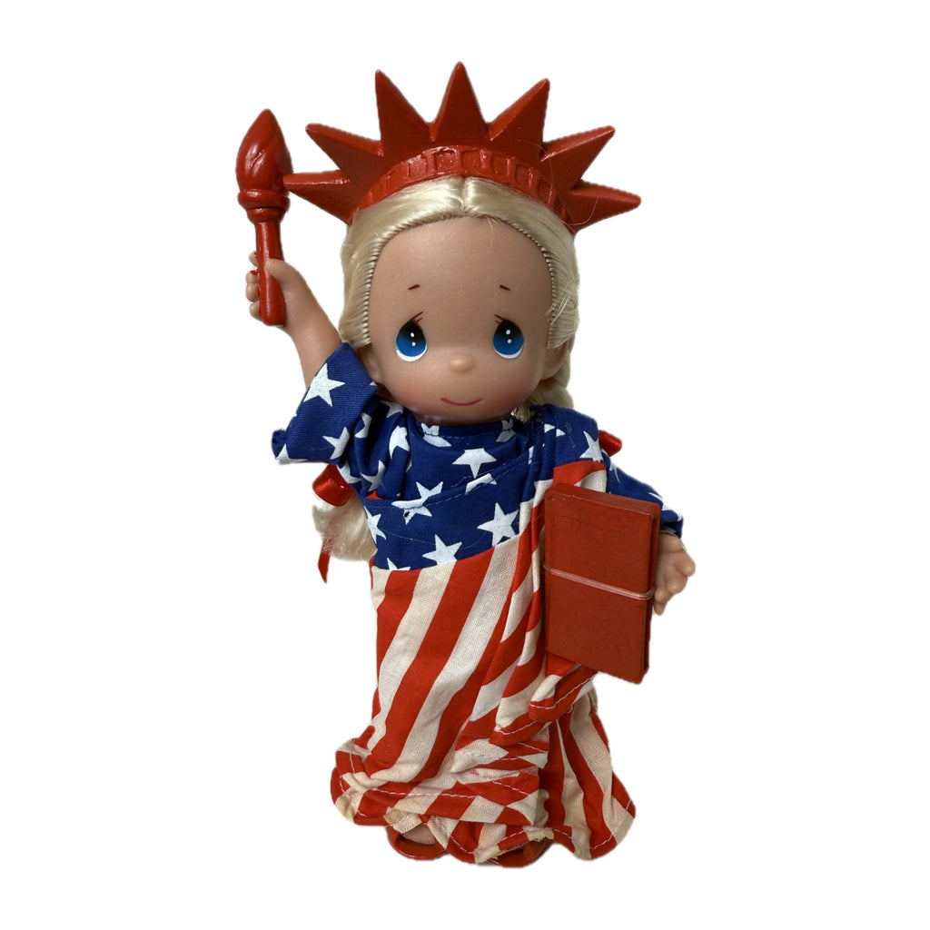 The Doll Maker 7-inch Statue of Liberty vinyl doll wearing a star-spangled banner robe with a red torch and crown.