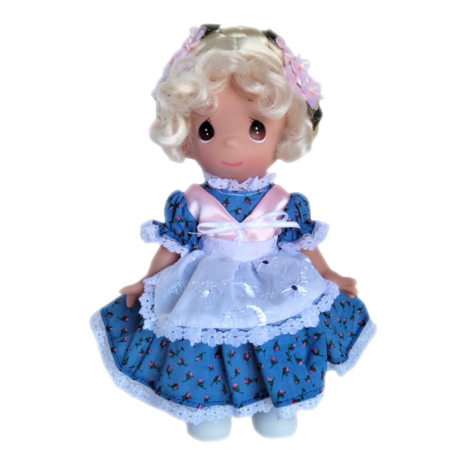 The Doll Maker Switzerland Julian 9-inch vinyl doll wearing a blue floral dress with a white apron and flower headband.