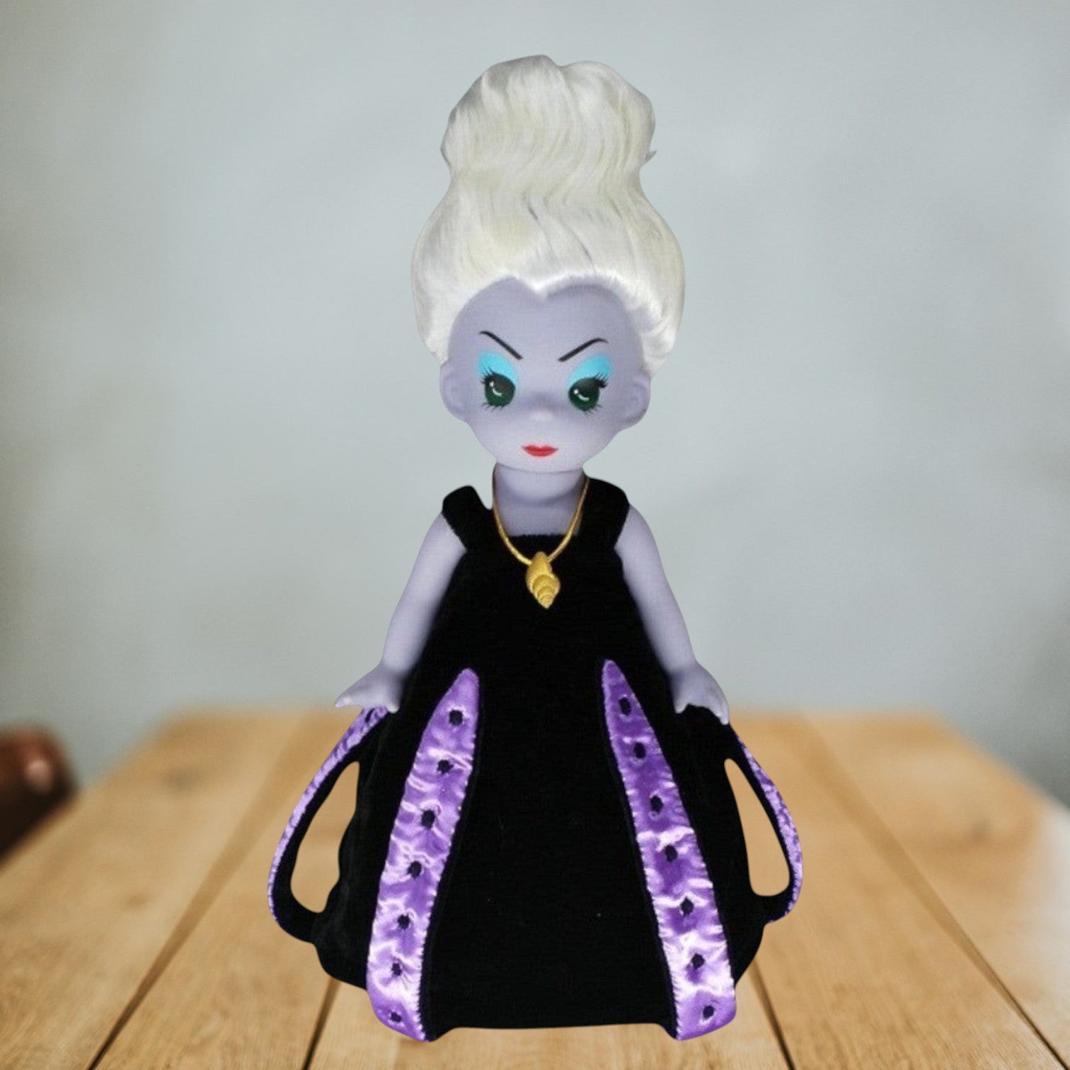The Doll Maker 12-inch Ursula vinyl doll from The Little Mermaid with white hair, black dress, and gold shell necklace.