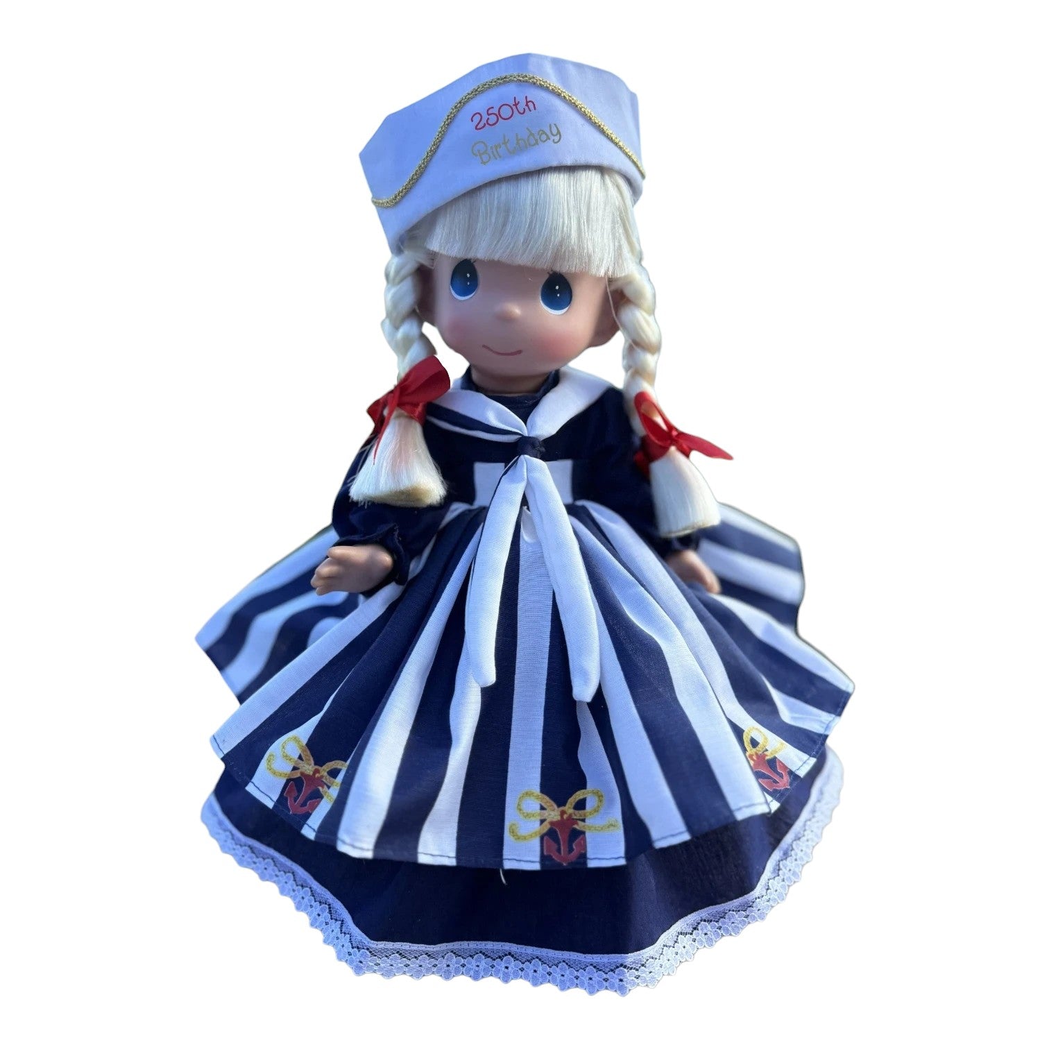 The Doll Maker 12-inch commemorative doll in a navy and white sailor dress with 250th birthday hat and anchor details.