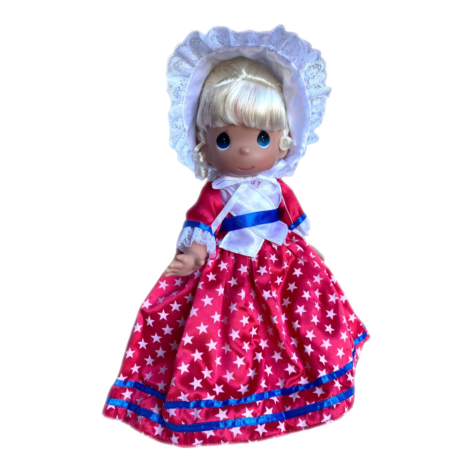 The Doll Maker 12-inch collectible doll wearing a red dress with white stars, blue trim, and a white lace bonnet.