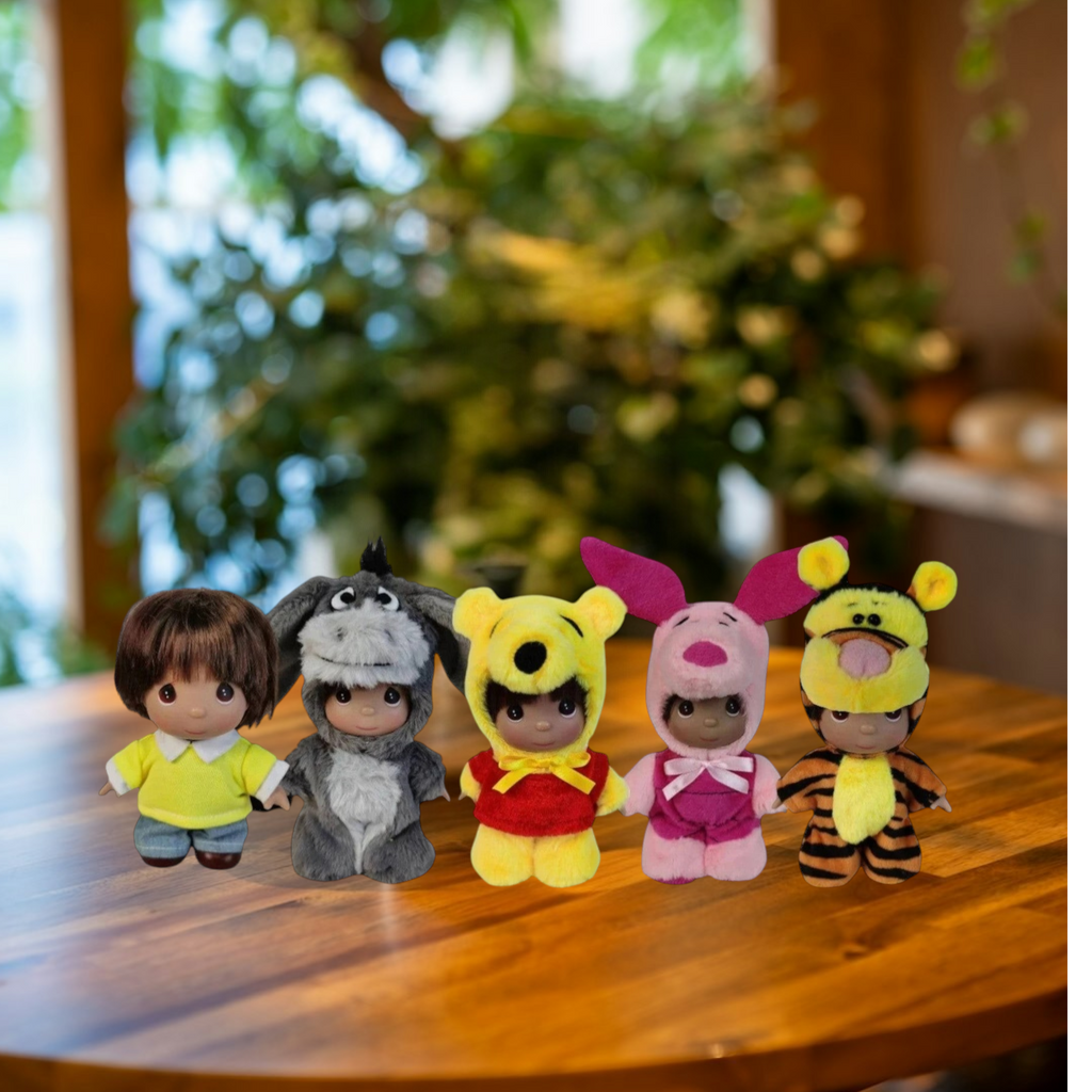 The Doll Maker Winnie the Pooh set of five 5-inch collectible dolls featuring character costumes on a wooden table.