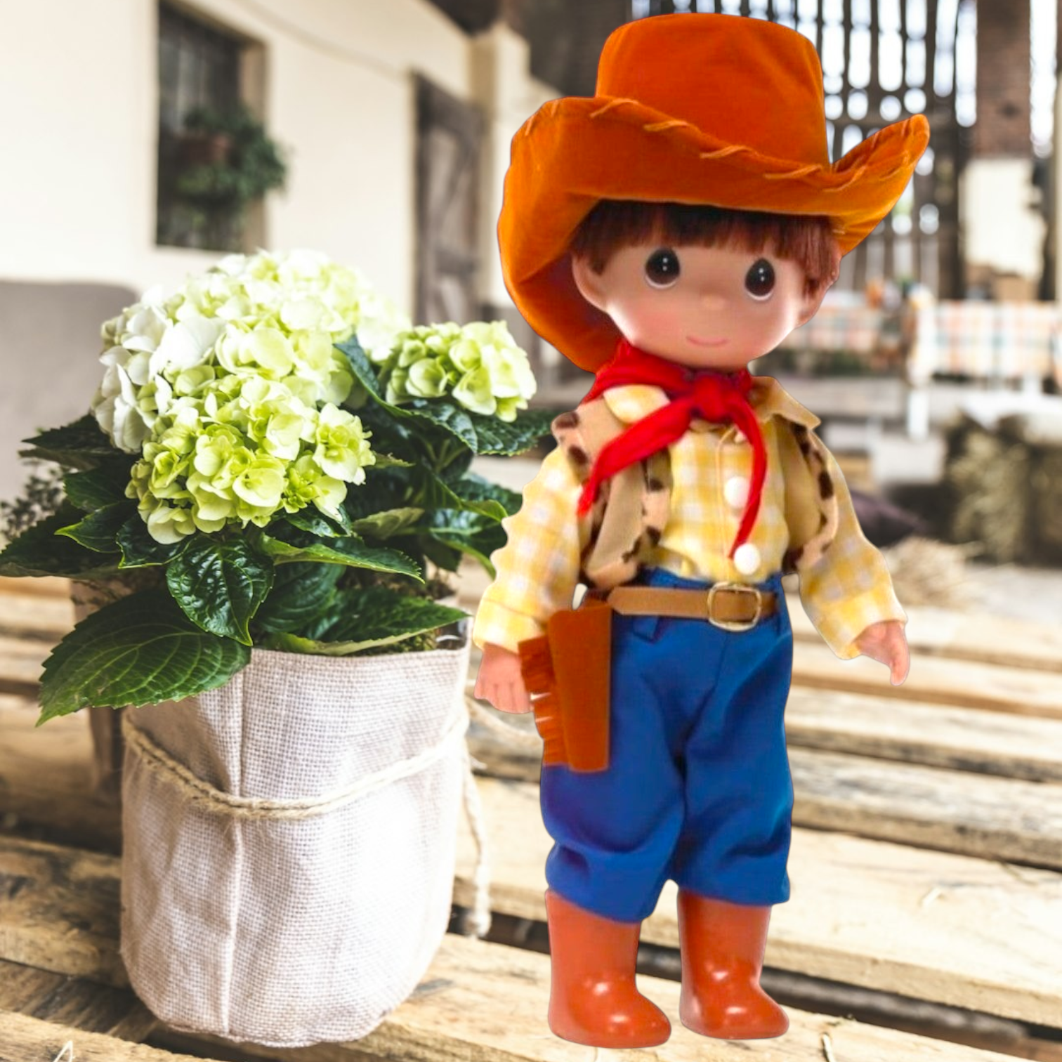 The Doll Maker 12-inch Woody cowboy doll from Toy Story wearing a yellow plaid shirt, blue pants, and brown hat.
