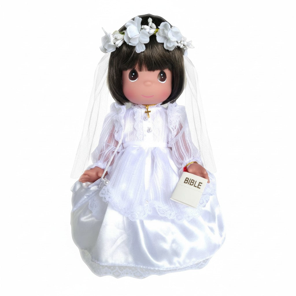 The Doll Maker brunette First Communion doll in white satin gown, veil, and gold cross necklace, holding a Bible.