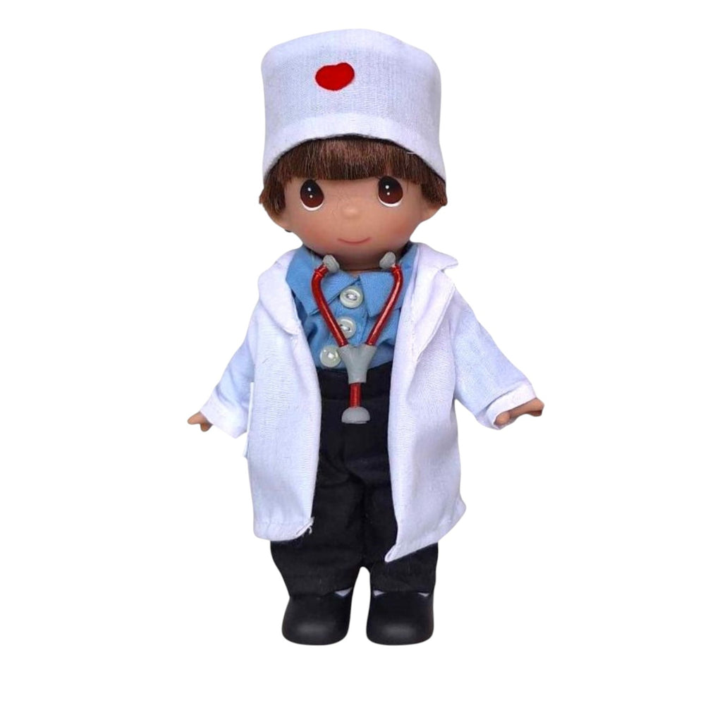 The Doll Maker Caring Heart Dr boy doll, 7-inch vinyl doctor with stethoscope, blue shirt, black pants, and white coat with red heart detail.