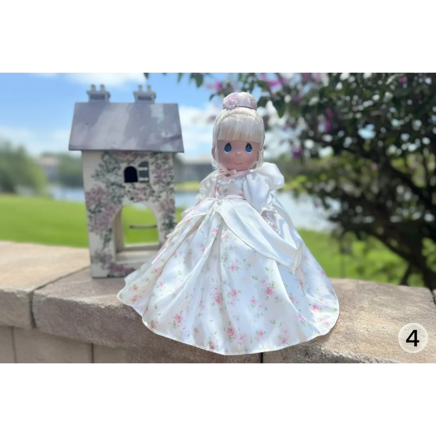 The Doll Maker's 12-inch Spring Bouquets doll in a white satin gown with pink floral print and delicate pink trim.