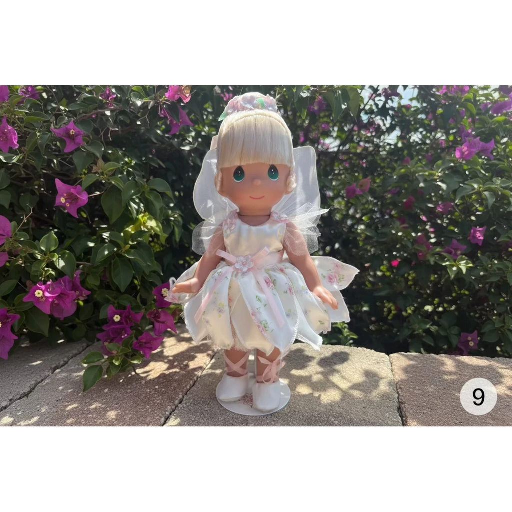 The Doll Maker Spring Bouquets 12 inch fairy doll in a white floral dress .