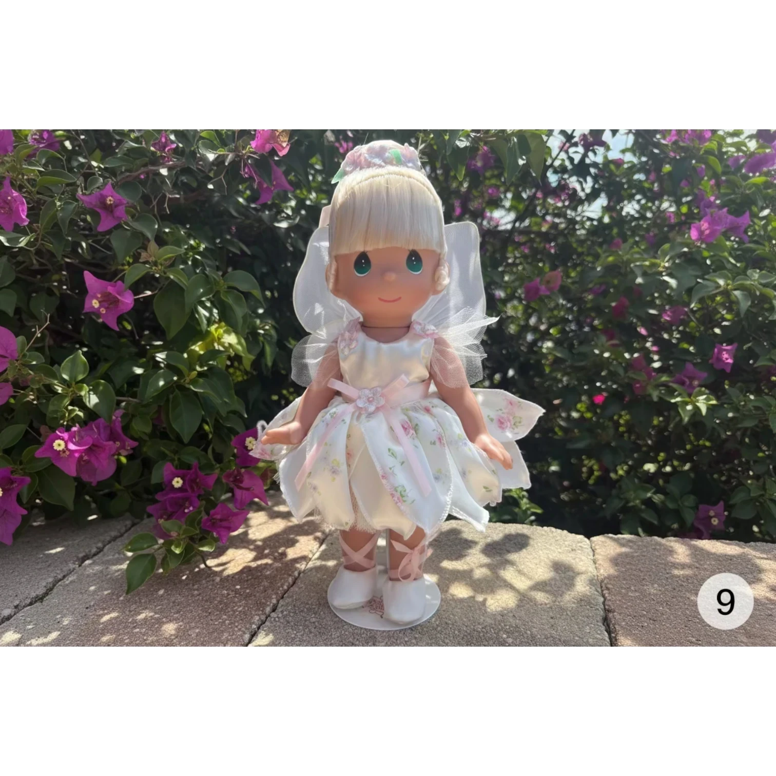 The Doll Maker Spring Bouquets 12 inch fairy doll in a white floral dress .
