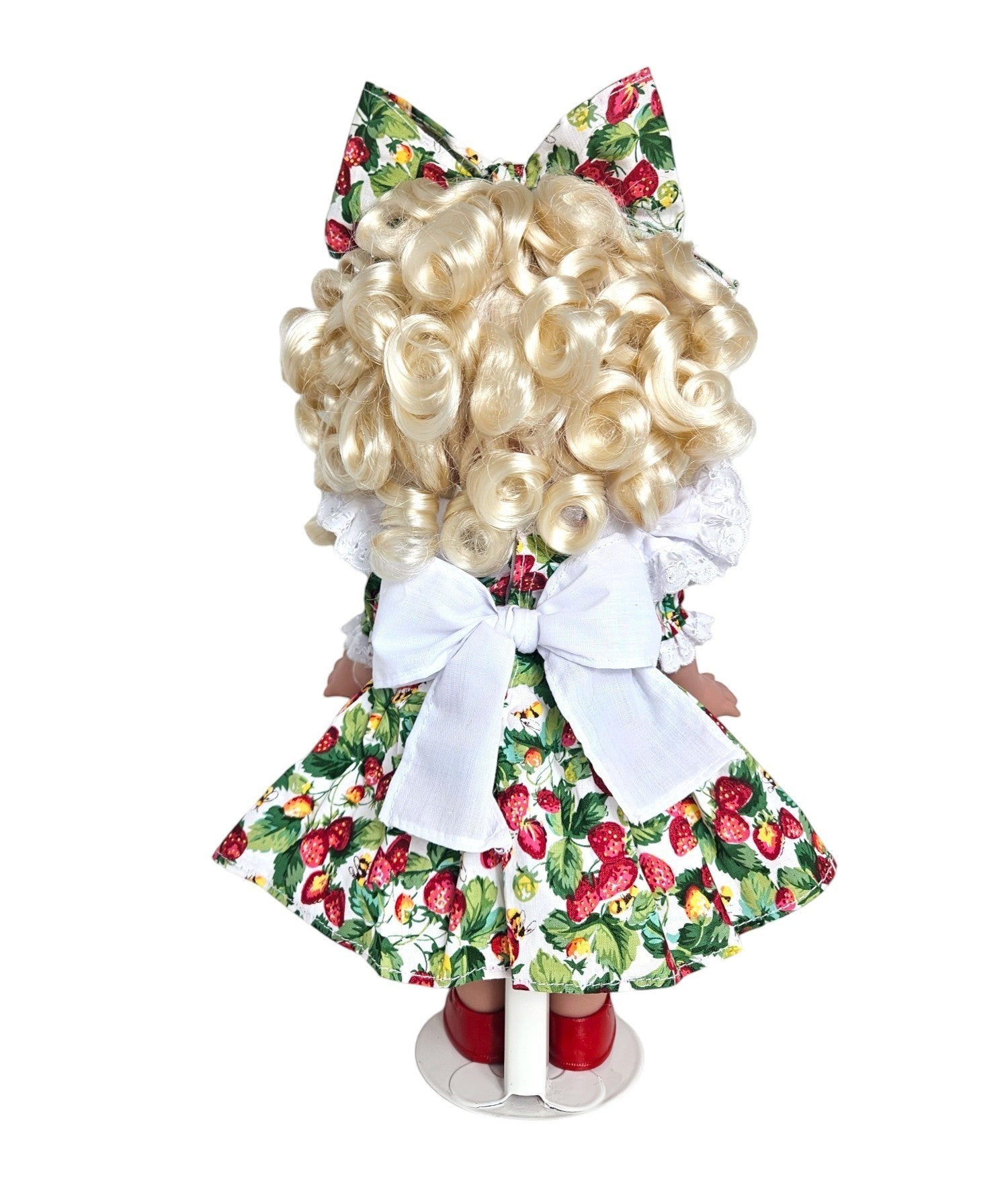 The Doll Maker's You're Berry Sweet 12" doll with blonde curly hair, wearing a strawberry print dress and red shoes.
